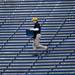 A concession employee carries food through empty aisles during the alumni spring flag football game on Saturday, April 13. AnnArbor.com I Daniel Brenner